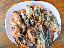 A plate of grilled shrimp on a table photo