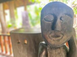 A wooden statue of a man with a face photo