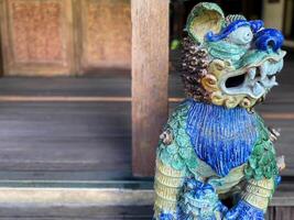 A statue of a lion with a blue and green design photo