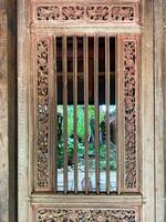 An old wooden door with a window and a wooden frame photo