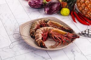 A plate with two large shrimp and a pineapple photo