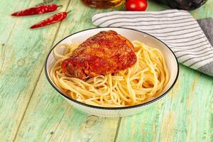 Spaghetti with meatballs in a bowl on a wooden table photo