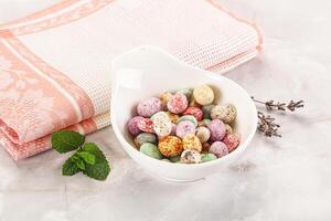 A bowl of colorful candy and a towel photo