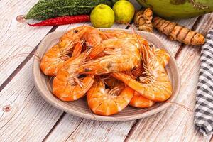 A plate of cooked shrimp and vegetables on a table photo