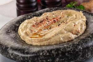 A bowl of hummus with a spoon on top photo