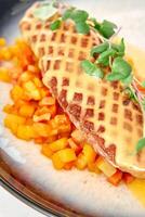 Grilled fish with honeycomb pattern on roasted vegetables and microgreens photo
