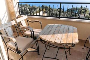 Rustic balcony seating with ocean view and weathered wooden furniture photo