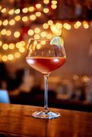 Elegant cocktail glass with lemon garnish in warm ambient lighting photo