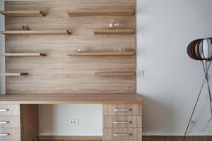 Minimalist wooden desk with floating shelves and modern floor lamp photo