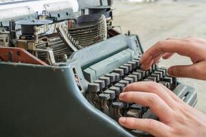 A person typing on an old typewriter photo