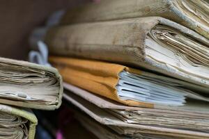 A pile of old documents sitting on top of a desk photo