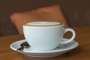 A white cup of coffee sitting on a saucer photo