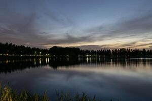A lake at dusk with a park in the background photo