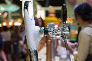 A beer tap is being filled with foam photo