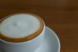 A cappuccino is sitting on a saucer photo