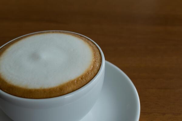 A cappuccino is sitting on a saucer