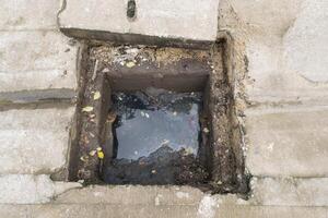 A hole in the ground with a small hole in it photo