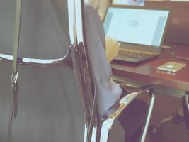 A person sitting in a chair with a laptop computer photo