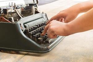 A person typing on a typewriter photo