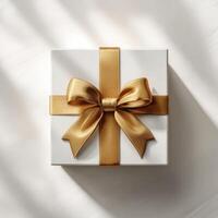 Golden gift box with ribbon and bow on white background photo