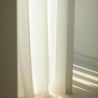 A white curtain is sitting in front of a window photo