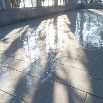 A tile floor with sunlight shining through the windows photo