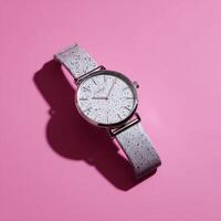 A silver watch on a pink background photo