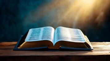 Open holy bible resting on wooden table with dramatic lighting photo