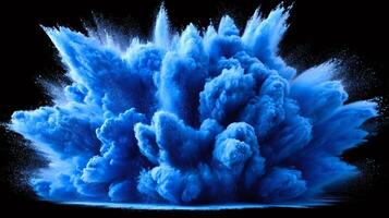 Blue powder exploding creating a vibrant cloud on black background photo
