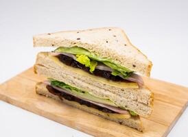 Classic Butcher Ham and Cheddar Cheese Sandwich with Lettuce and Chutney on wooden board side view on white background photo