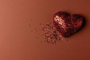 Colorful Glitter Heart on Brown Background With Scattered Sparkles for Celebration or Decoration photo