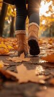 Autumn Walk in the Park With Brown Boots on a Path Covered in Fallen Leaves photo
