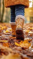 Autumn Walk in the Park With Brown Boots on a Path Covered in Fallen Leaves. photo