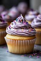 Purple frosted cupcake with sprinkles photo
