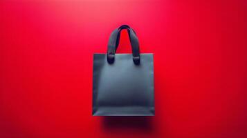Stylish Black Shopping Bag on Vibrant Red Background for Retail or Marketing Purposes photo