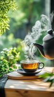 Steaming cup of tea with teapot photo