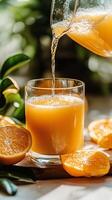 Pouring fresh orange juice into a glass photo