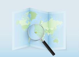 A folded world map with a magnifying lens pointing towards Guinea-Bissau. Map and flag of Italy in loupe. vector