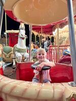 Child Enjoying Carousel Ride at Night Carnival photo
