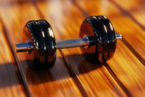 Single black dumbbell rests on polished wood gym floor, reflecting warm light of setting sun photo
