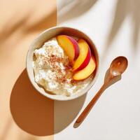 Creamy cottage cheese in a bowl, topped with sliced peaches and a sprinkling of cinnamon photo