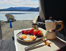 Landscape photography from tent with breakfast food, strewberry, egg, tomato, coffee photo