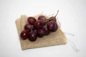 Fresh red grapes placed on a rustic piece of burlap fabric, simple and natural. photo