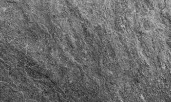 Rough dark slate stone texture with natural striations, ideal for backgrounds or surface design photo