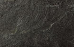 Close-up of natural dark slate stone surface with rough, layered texture photo
