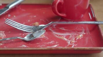 Empty plate and utensils on a red tray video