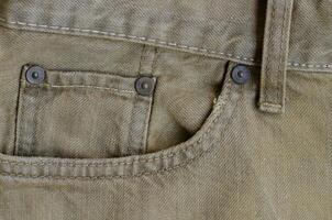 Texture of Old Brown Denim Jeans with Part of Trousers photo