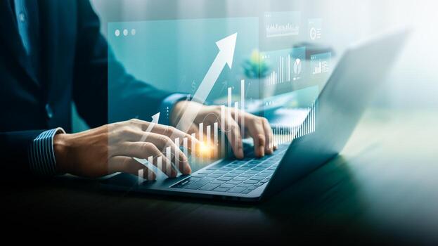 Businessman analyzing growth data using digital dashboard and laptop. Futuristic interface showing rising graph and financial metrics. Concept of smart investment, fintech, and business performance. photo
