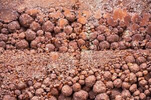 Close up of rough earthen wall texture. These walls are constructed by ramming a mixture of aggregates, including gravel, sand, silt and a small amount of clay. photo