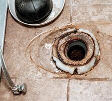 Close-up image showing the process of replacing the wax ring under a toilet with copy space. photo
